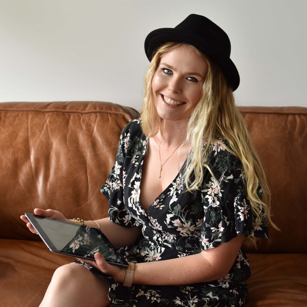 Sarah, freelance copywriter at Poppins Copy, sits on a couch